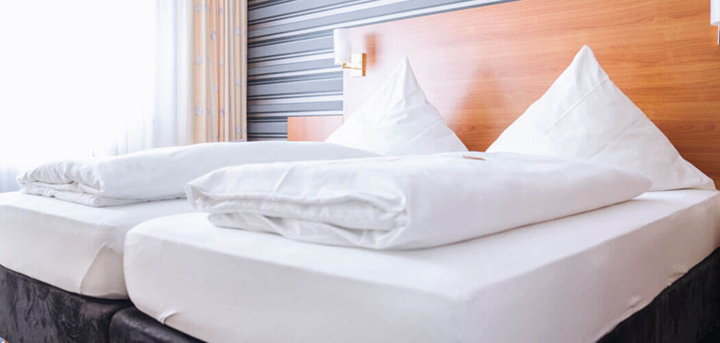 Komfortables Doppel-Bett in einer großzügigen Suite im Hotel Alexa Bad Mergentheim